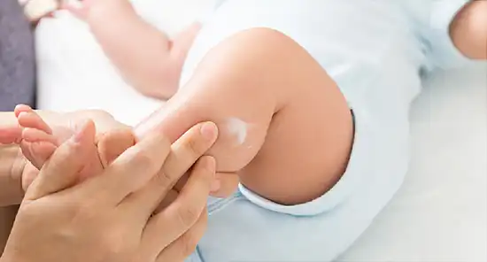 photo of applying lotion to baby's leg