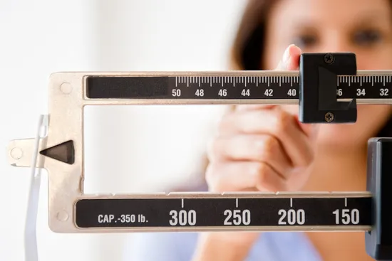 woman checking weight on scale