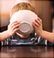 boy drinking from cereal bowl