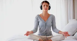 woman meditating with music