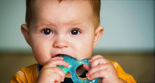 Baby chewing on teething ring