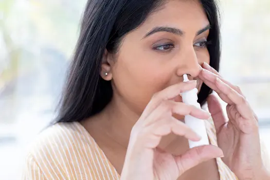 photo of woman using nasal spray