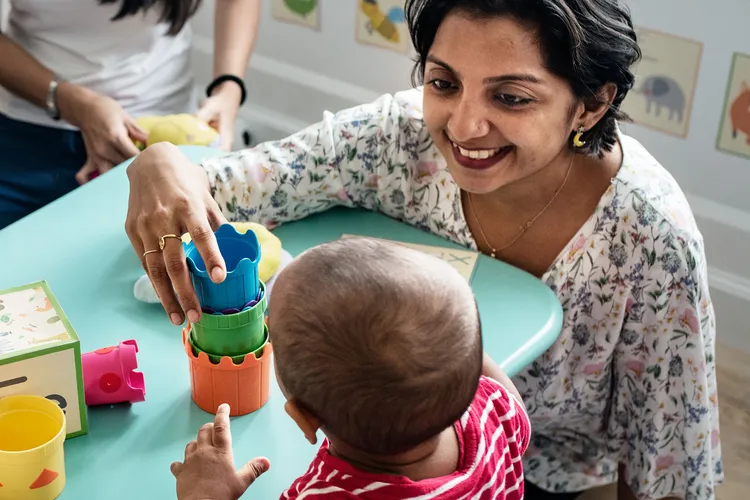 photo of teacher playing with boy in nursery