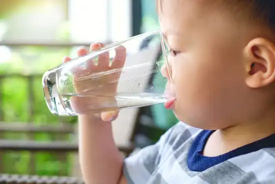 photo of toddler baby boy drinking glass of water