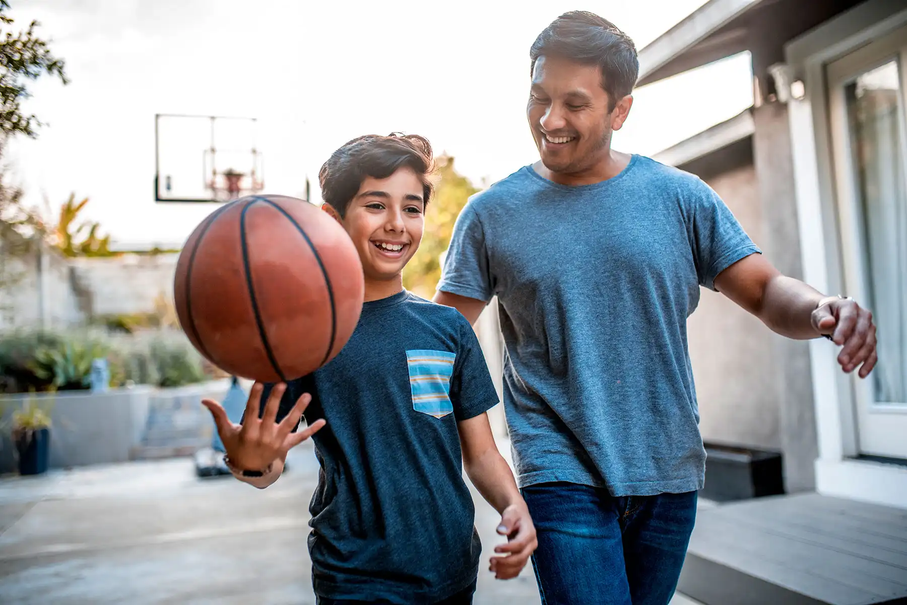 photo of father and son playing basketball