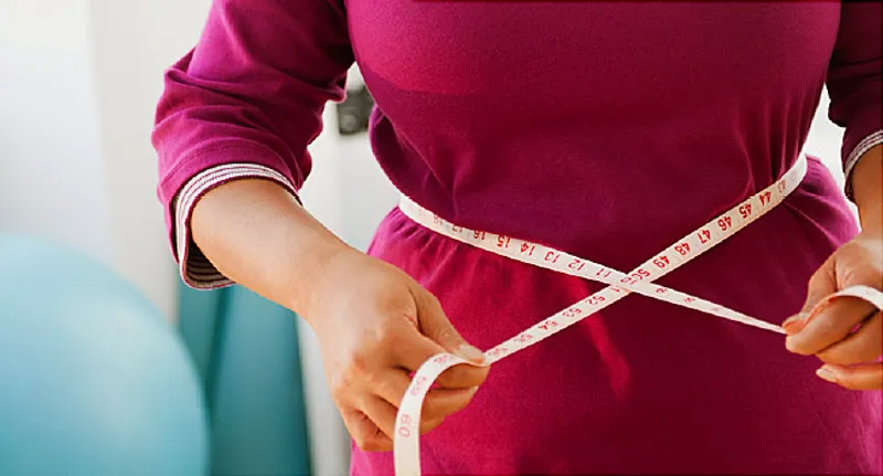 woman measuring her waist size