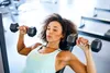 photo of woman lifting hand weights in gym
