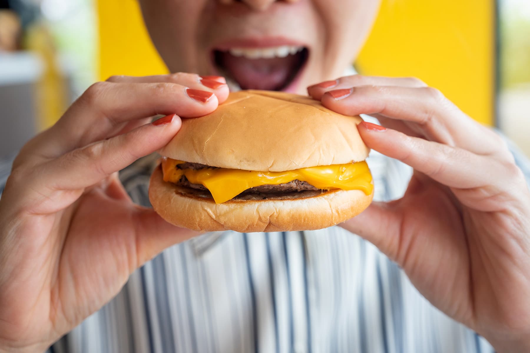 photo of person eating cheeseburger