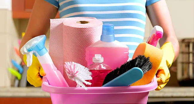 woman with tub of cleaning supplies