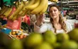 photo of woman selecting bananas at grocery store