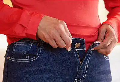 woman buttoning jeans