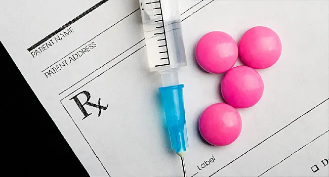 pills and syringe on prescription