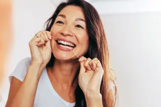 photo of woman flossing her teeth
