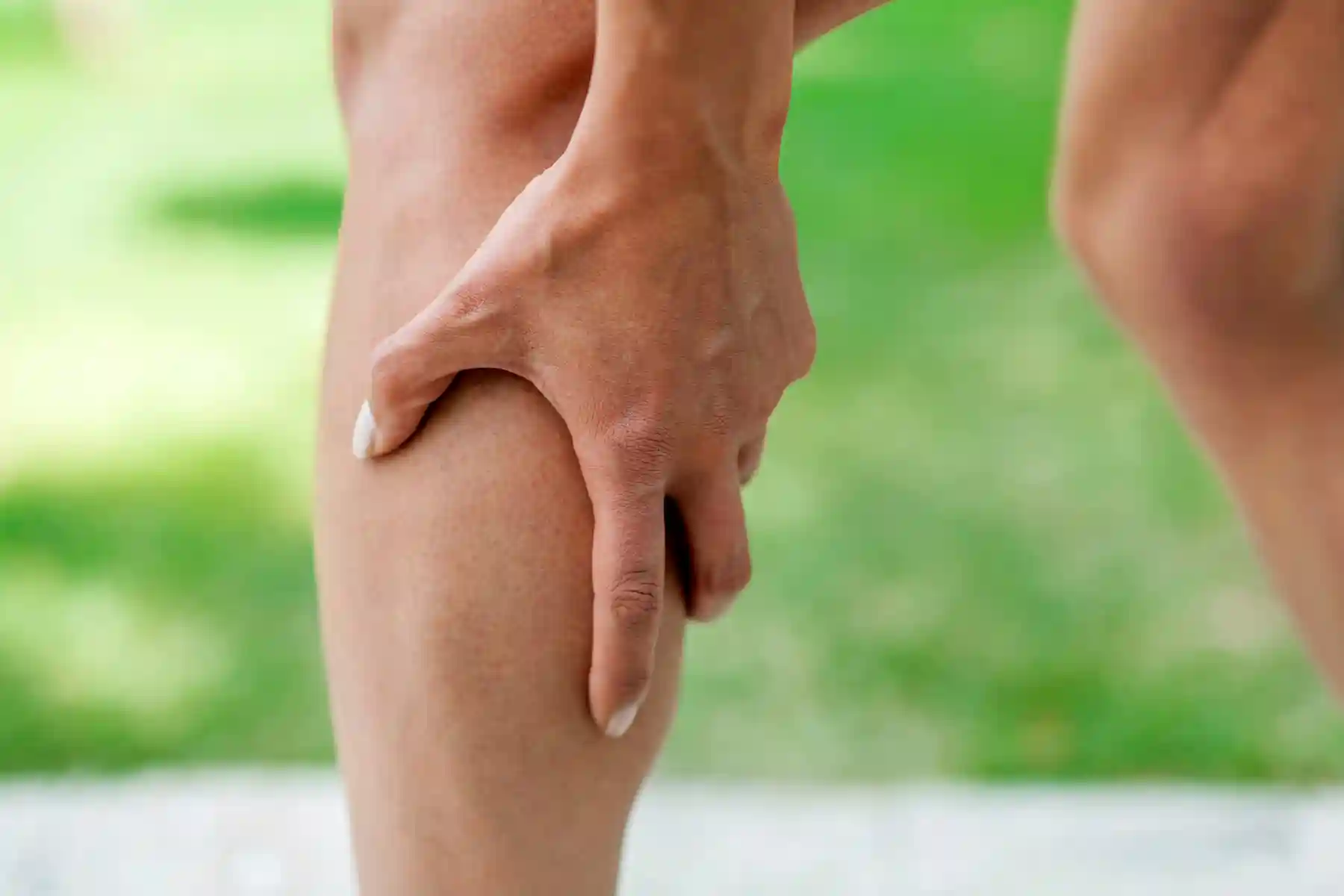 photo of man holding sore calf muscle
