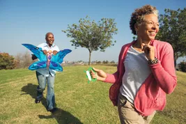 photo of mature couple playing with kite