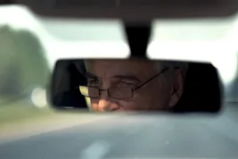 photo of man in rear view mirror
