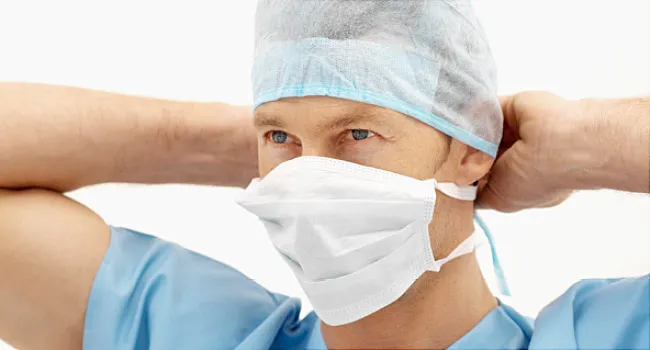 surgeon tying his surgical mask