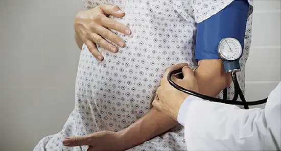 doctor taking pregnant woman blood pressure