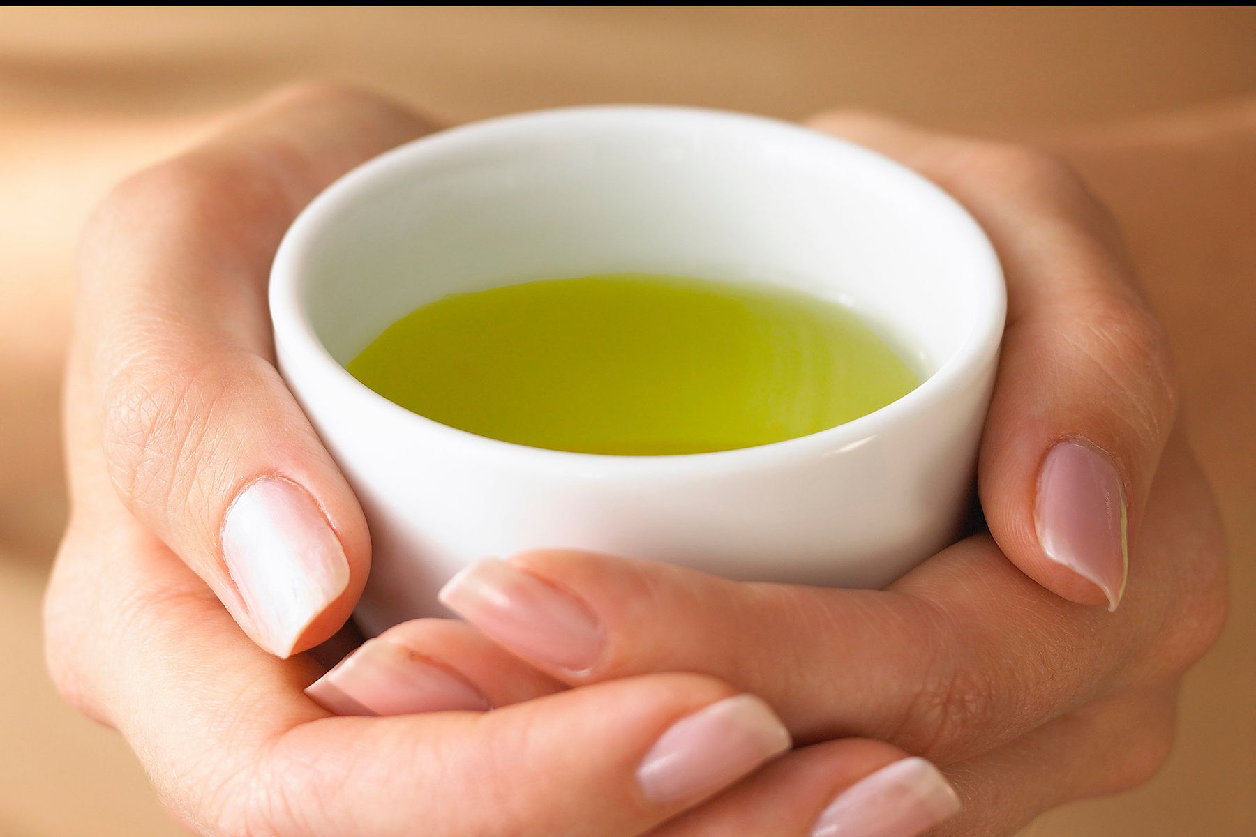 hands holding cup of green tea