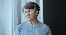 elderly woman looking out the window