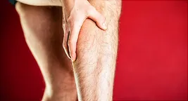 man holding thigh