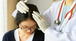doctor checking woman's scalp