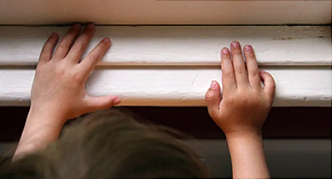 kid with hands on windowsill