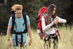 photo of young man and woman backpacking