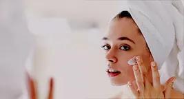 woman moisturizing face
