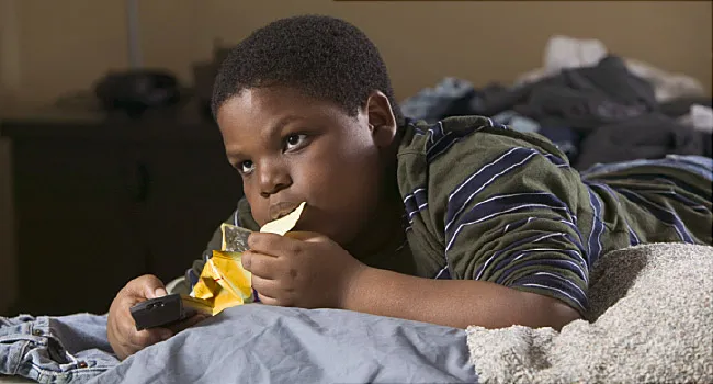 boy on bed eating chips