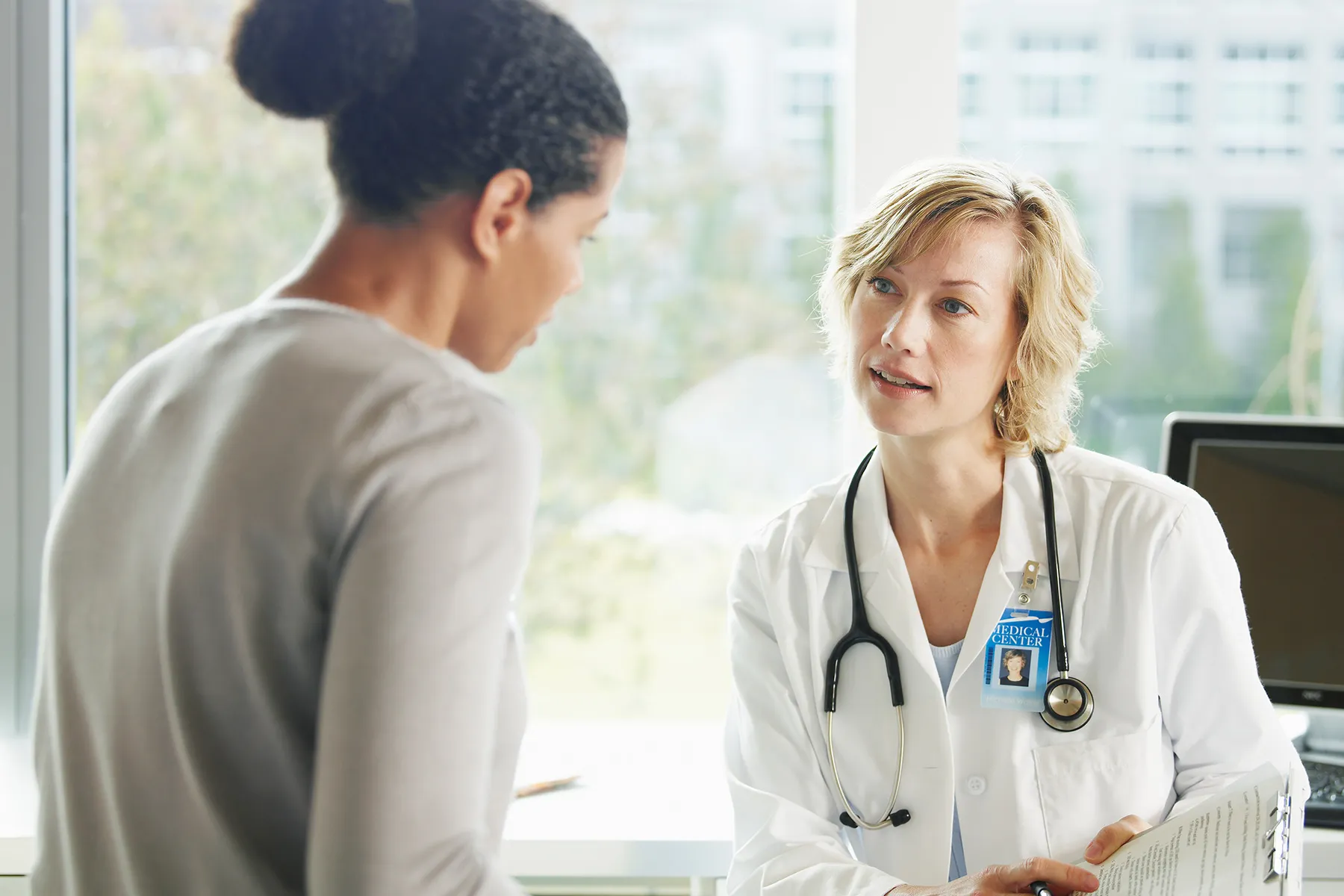 photo of woman talking to doctor