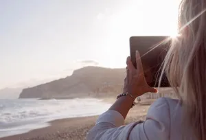 woman taking picture of surf