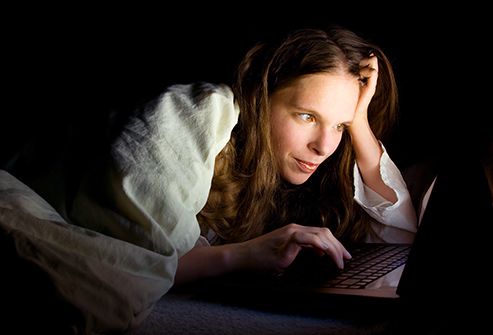 woman using laptop at night