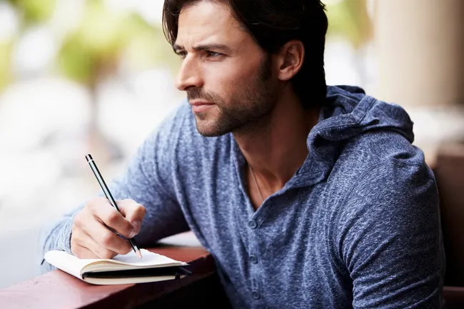 photo of man writing in journal