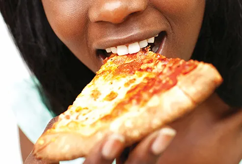 young woman eating pizza slice