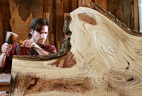 Carpenter chiseling a large section of a tree trun