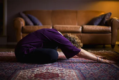 Mulher praticando ioga em casa