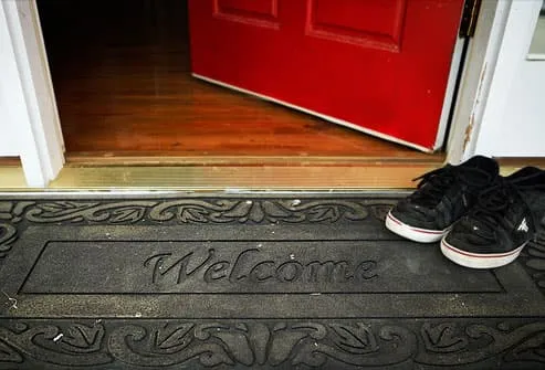 Shoes on rubber welcome mat at front door