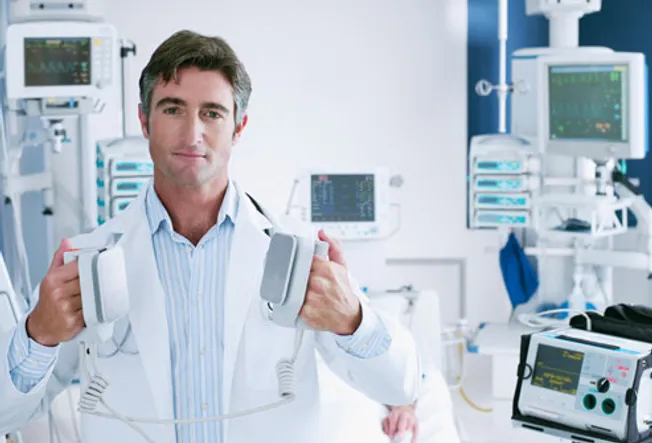 Doctor Holding Defibrillator Paddles