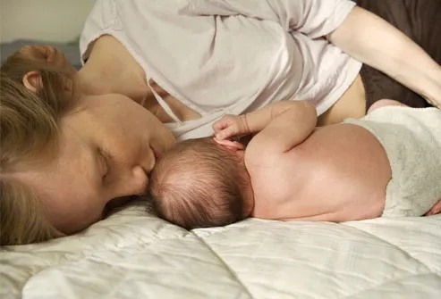 Woman Kissing Baby While Breastfeeding