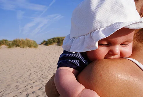 Baby with floppy hat on sunny dune 