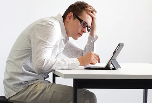 man hunched over tablet