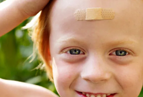 Smiling Child With Bandage on Forehead