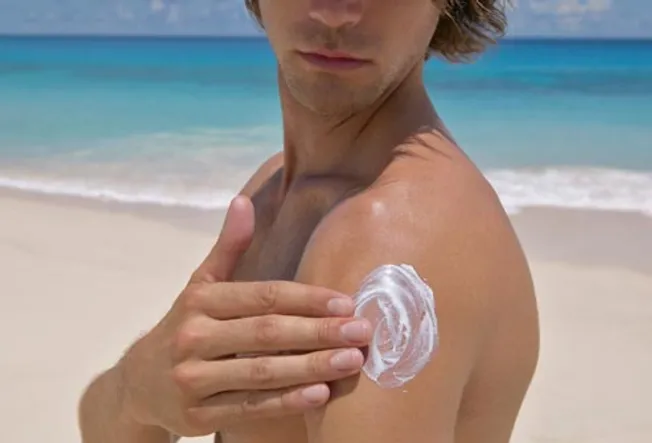 man putting sunscreen on arm