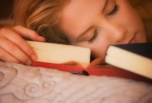 student sleeping with books