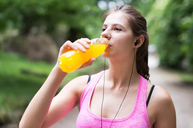 photo of woman sipping sports drink