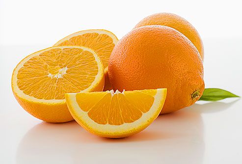 Whole and cut oranges, close-up