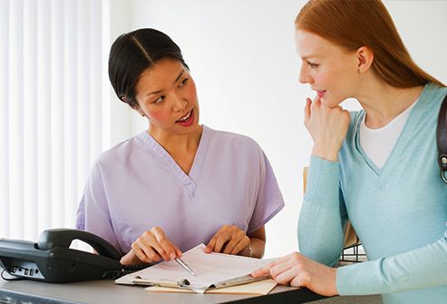 nurse helping woman with paperwork