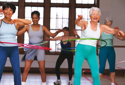 Mature women using hula hoops in exercise class