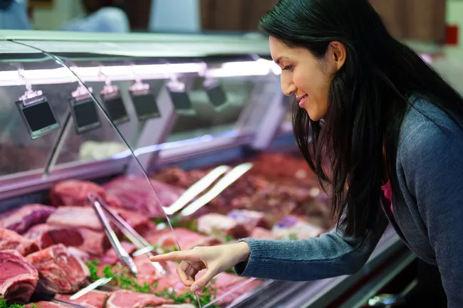 photo of woman shopping for meat